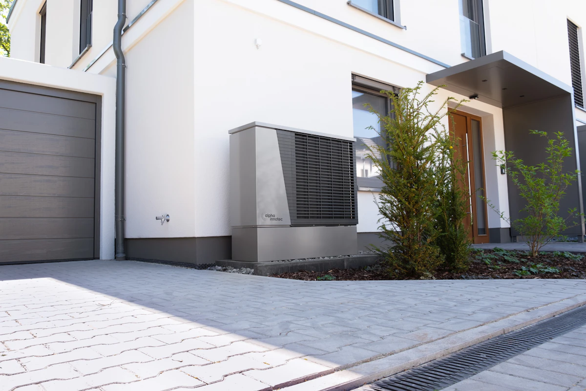 A modern house with a heat pump unit on the outside wall